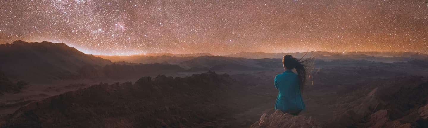 woman looking at mountain desert at night