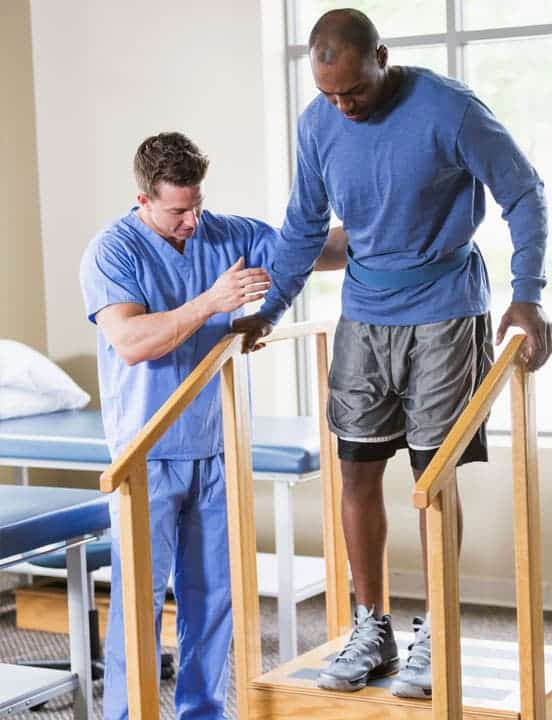 nurse helping man walk down stairs