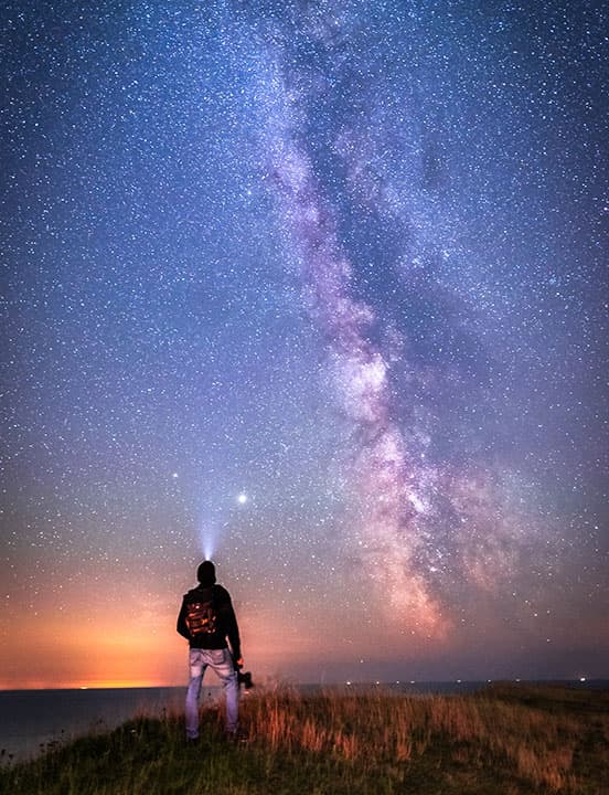 man looking at milky way galaxy