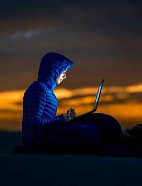 woman working on laptop at sunset