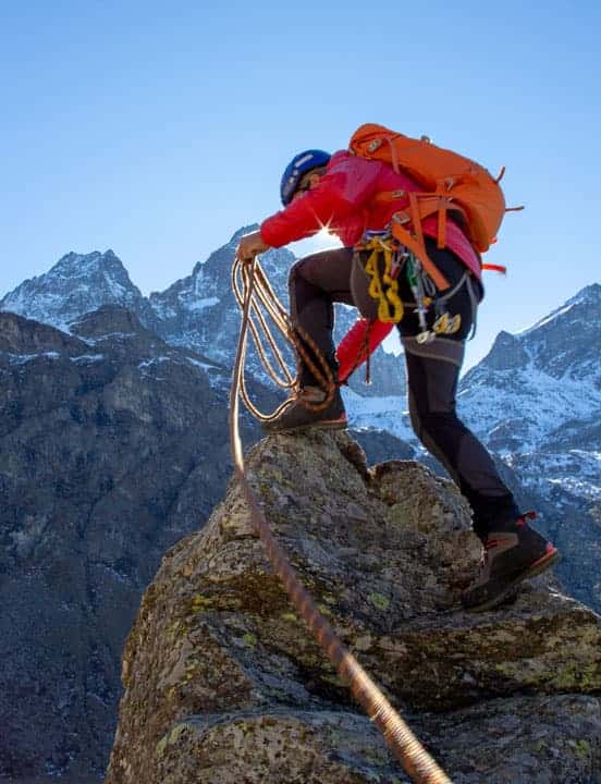 person preparing to climb down cliff