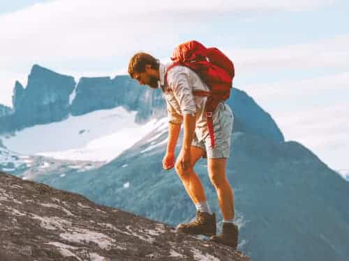 man climbing with backpack