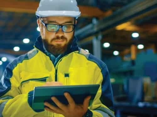 worker in hardhat with tablet