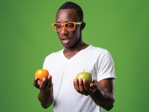 Man holding apple and orange
