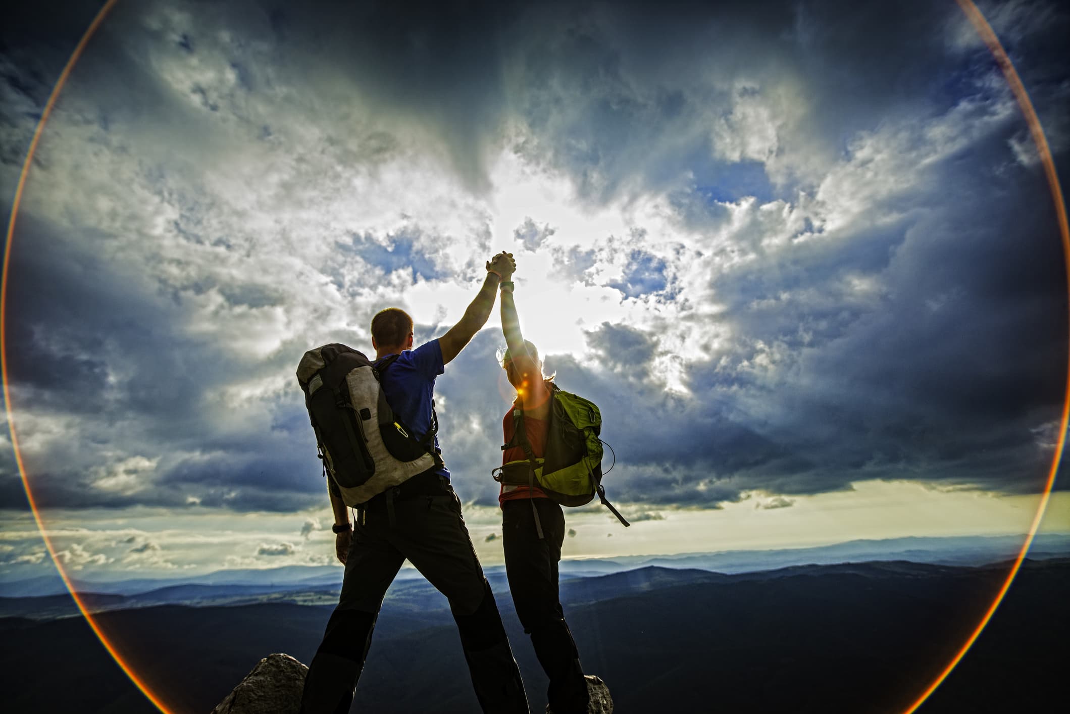 man and women high five on mountain peak