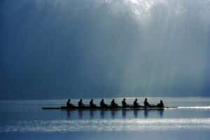 A canoe team rowing with power in order to win the competition